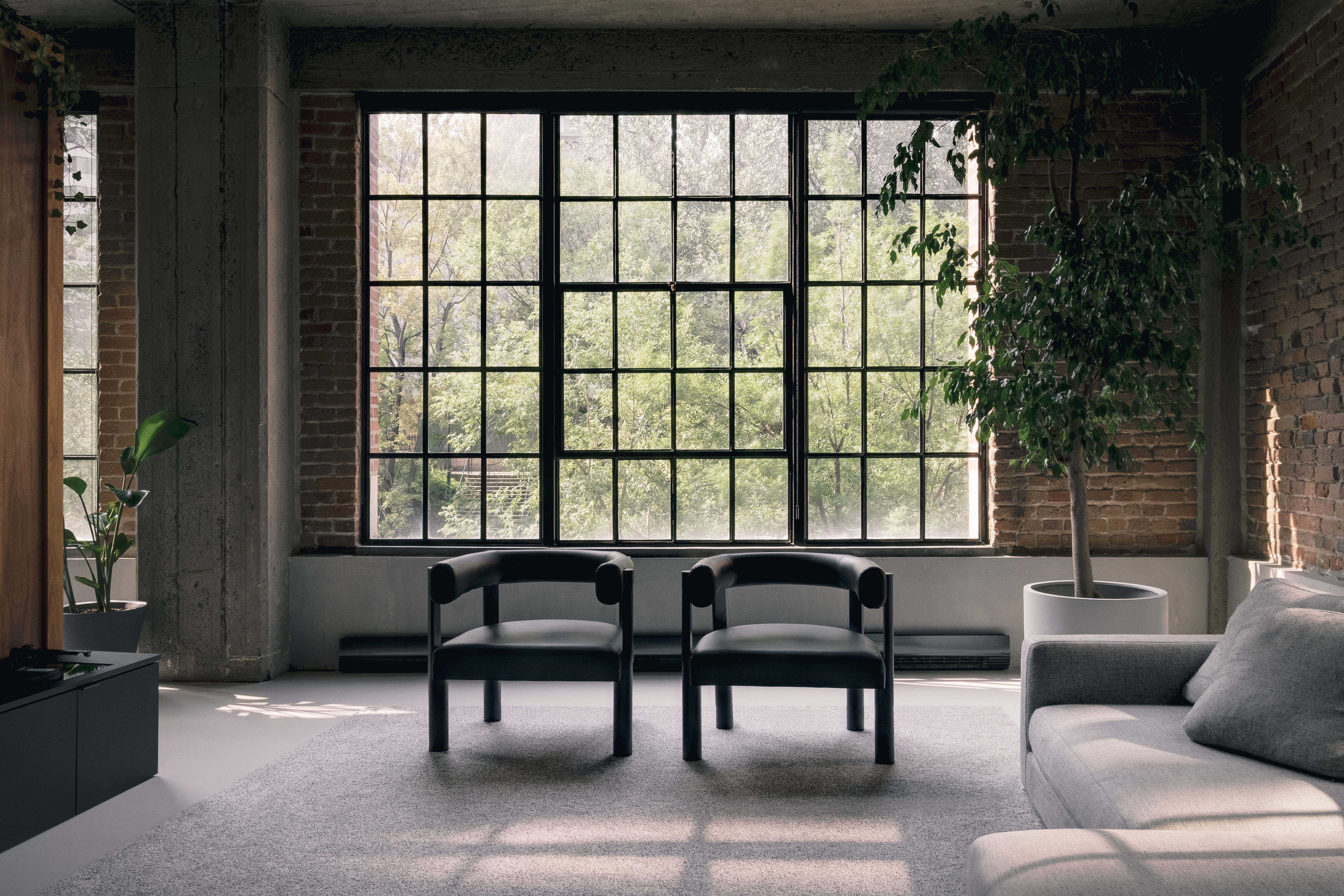 two cove chairs set against a multi-pane window in an industrial loft